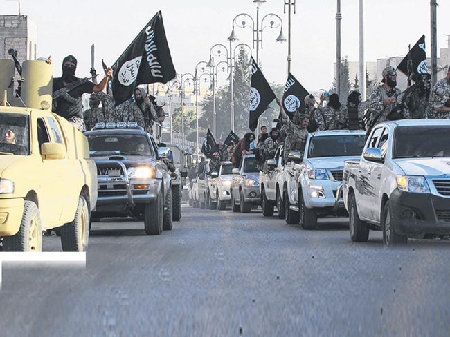 Militant Islamist fighters parade on military vehicles along the streets of northern Raqqa province.  Picture:  Reuters