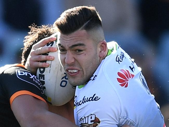 Nick Cotric of the Raiders (centre) is tackled by Elijah Taylor of the Tigers (left) during the Round 22 NRL match between the Canberra Raiders and the Wests Tigers at GIO Stadium in Canberra, Sunday, August 12, 2018. (AAP Image/Lukas Coch) NO ARCHIVING, EDITORIAL USE ONLY