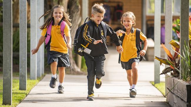 Lucy, 9, Isaac, 7 and Annabelle Smith, 6 show their excitement at being back at Gulmarrad Public School to see their friends. Photo: Adam Hourigan