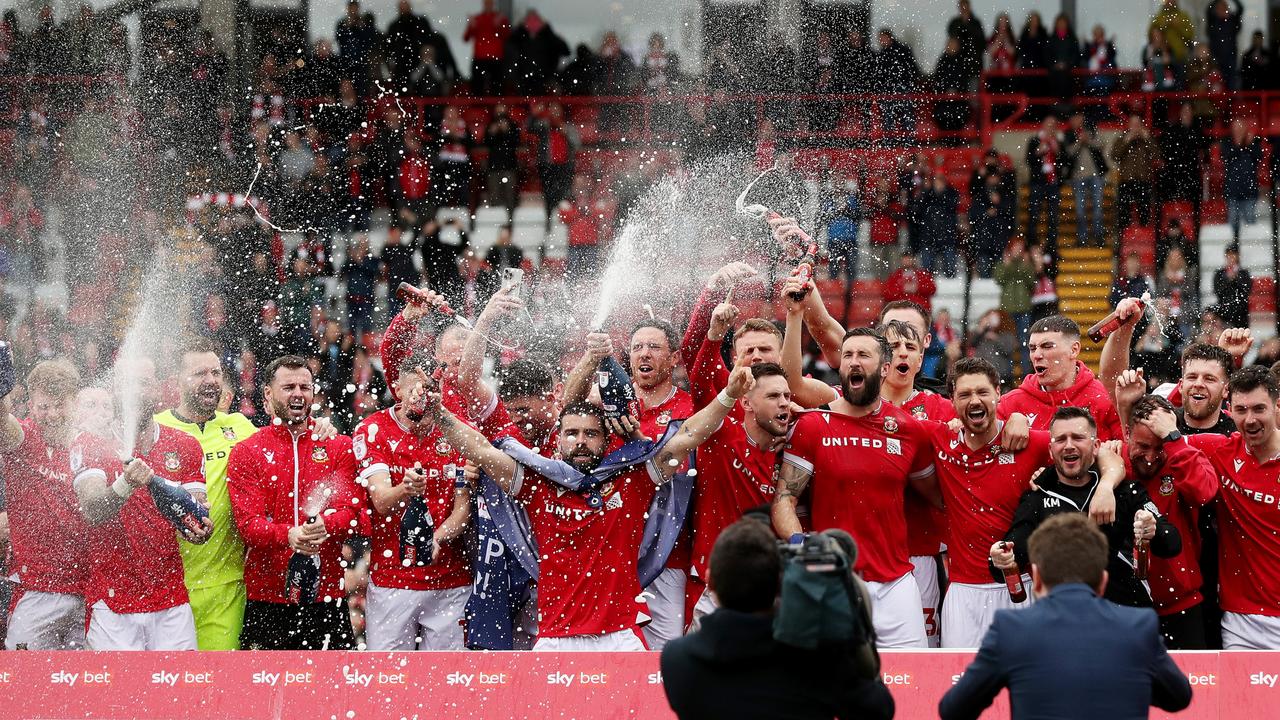 Players of Wrexham celebrate victory and promotion into League One. Photo by Charlotte Tattersall/Getty Images.