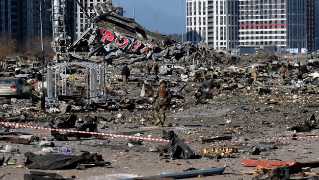 Soldiers and emergency workers secure and clean up debris around the Retroville shopping centre in Kyiv which was hit by a Russian missile. Picture: Getty