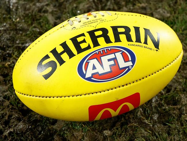 GEELONG, AUSTRALIA - JULY 20: The yellow Sherrin football is seen in mud during the 2024 AFL Round 19 match between the Geelong Cats and the Western Bulldogs at GMHBA Stadium on July 20, 2024 in Geelong, Australia. (Photo by Michael Willson/AFL Photos via Getty Images)