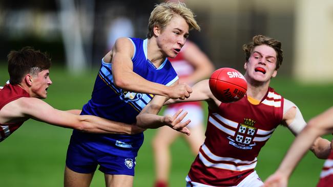 Sacred Heart’s Hamish Dunkin handballs while under pressure during his school’s clash with Prince Alfred on Saturday. Picture: AAP/Mark Brake