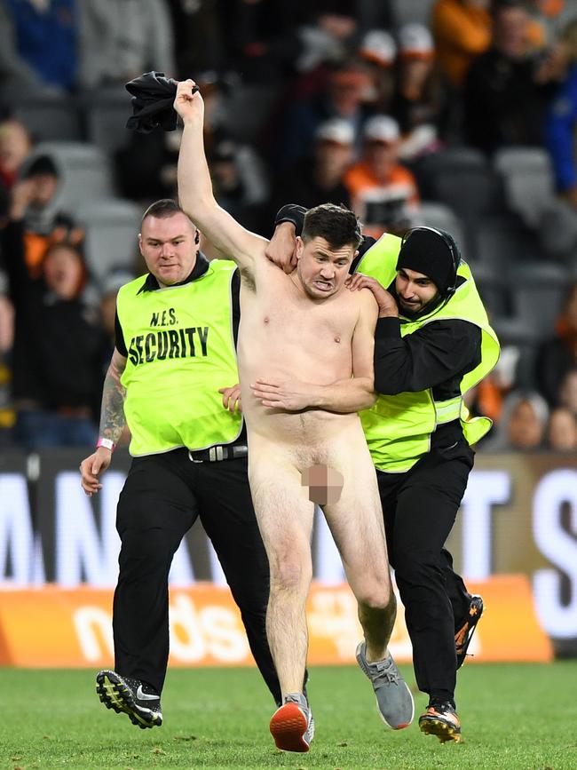 Streaker Matthew Cooper being chased by security guards at Bankwest Stadium. Picture: AAP/Joel Carrett