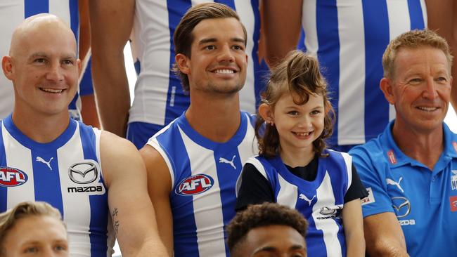 Jy Simpkin, middle with Ben Cunnington and coach David Noble, poses with North Melbourne fan and Royal Children’s Hospital patient Aubree. Picture: AFL Photos