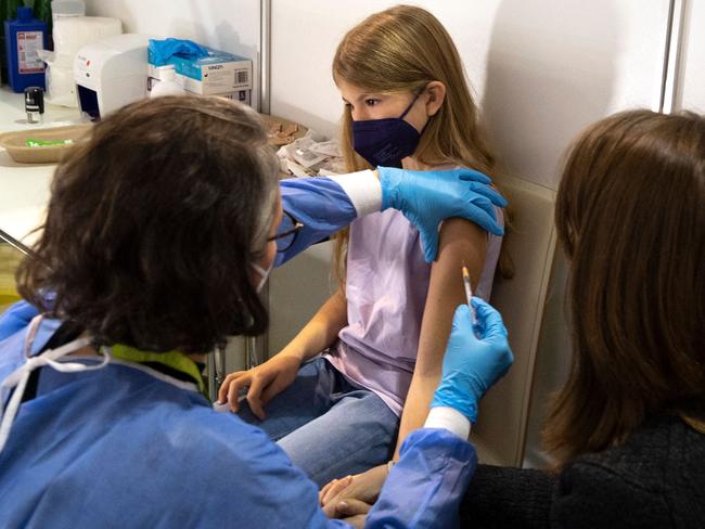 TOPSHOT - A girl receives her first shot of the corona vaccine in Vienna, Austria on November 15, 2021. - Authorities began vaccinating children between five and 11 against coronavirus in the capital on Monday among soaring rates that saw a country wide lockdown for some two million people who have not been fully vaccinated against Covid-19. (Photo by JOE KLAMAR / AFP)