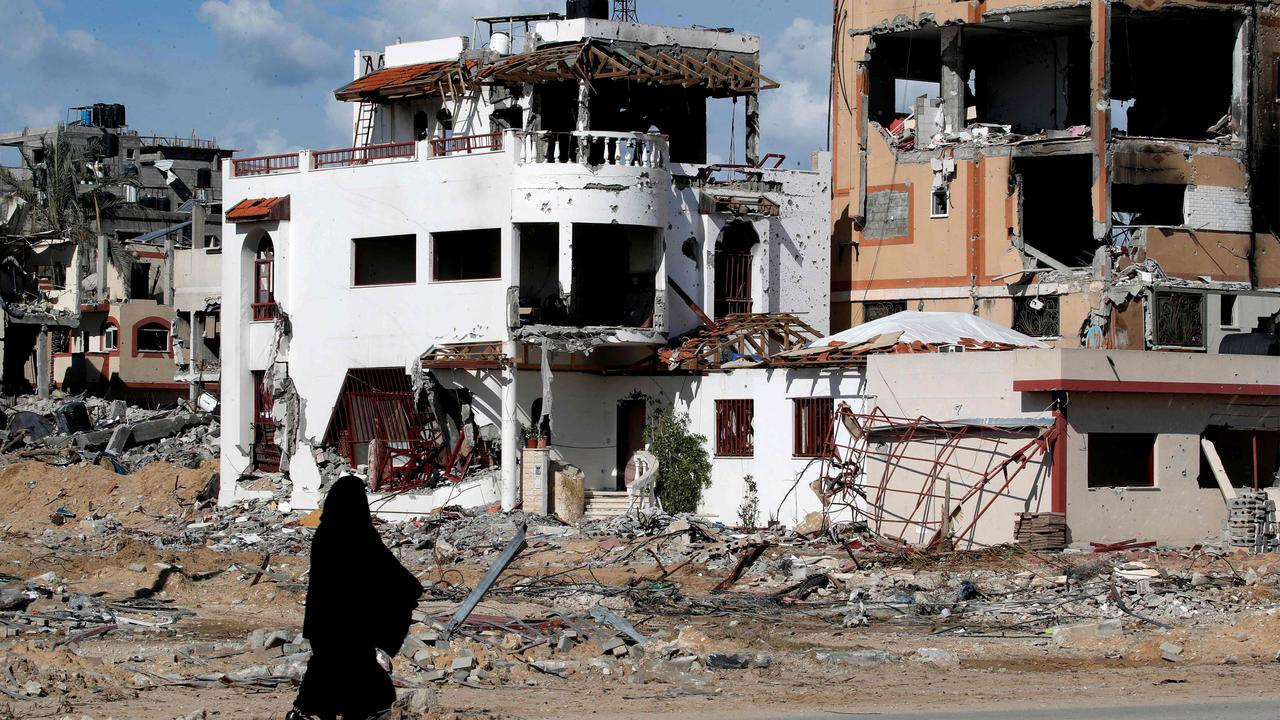 A woman walks past a destroyed building in the Maghazi camp for Palestinian refugees, which was severely damaged by Israeli bombardment, in the central Gaza Strip. Picture: AFP