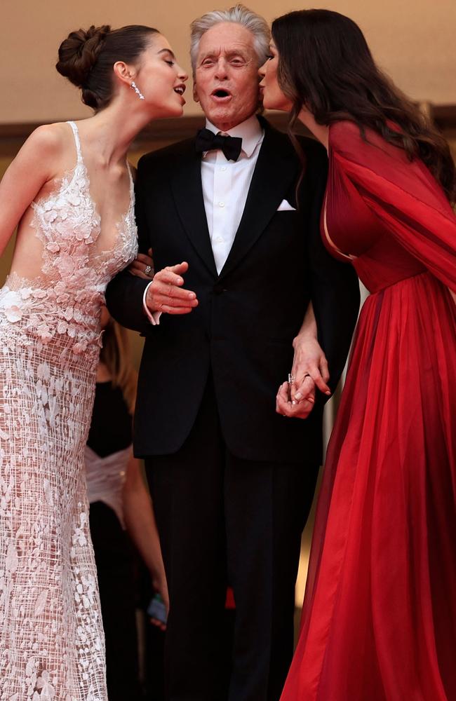 Carys and mum Catherine give Michael Douglas a kiss on the red carpet. Picture: Valery Hache/AFP