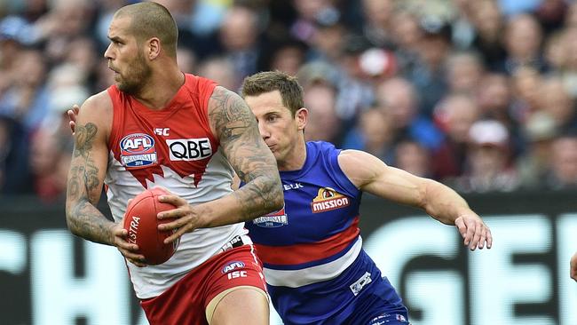 Lance Franklin is about to be tackled by Dale Morris.