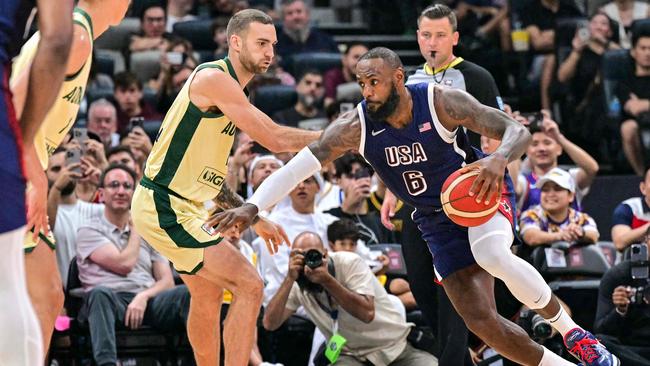 Australia's guard Jack McVeigh marks USA's forward #06 LeBron James during the Basketball Showcase friendly match between the United States and Australia at Etihad Arena in Abu Dhabi on July 15, 2024. (Photo by Giuseppe CACACE / AFP)