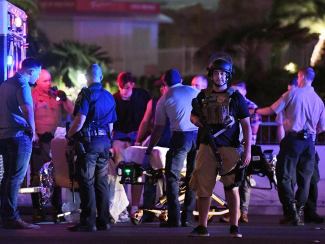 Police officers stand by as medical personnel tend to a person on Tropicana Ave. near Las Vegas Boulevard after a mass shooting at a country music festival nearby. Picture: Ethan Miller/Getty