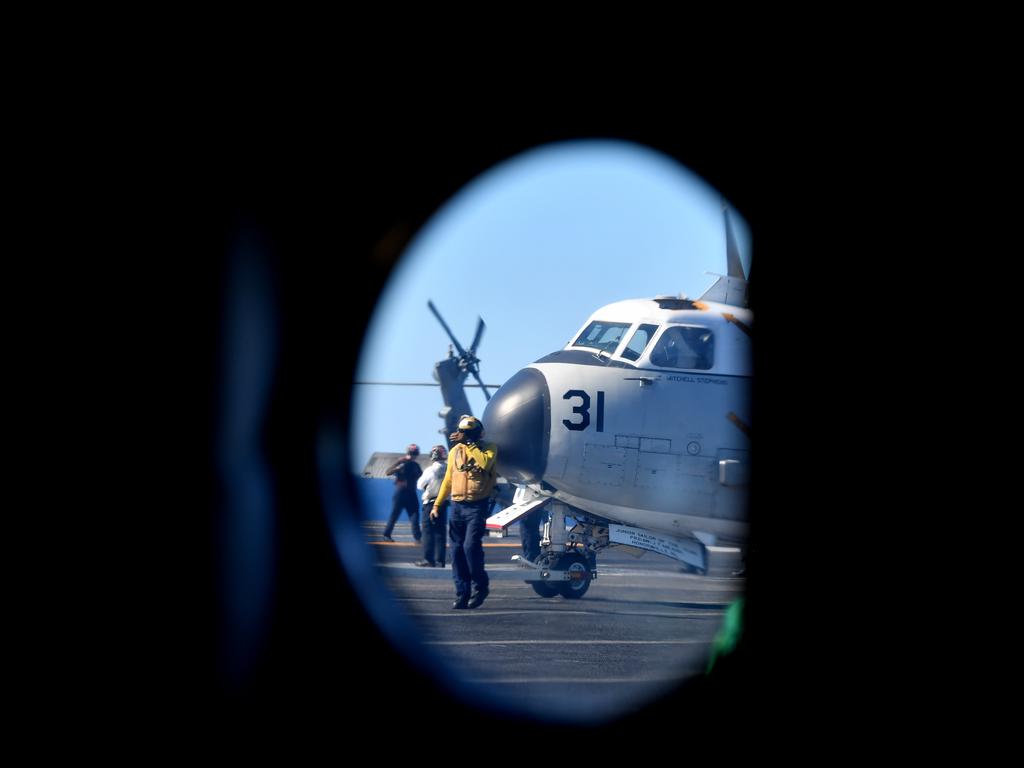 Aircraft are seen looking through a porthole on the flight deck of the USS Ronald Reagan, off the coast of Queensland, Australia, Friday, July 12, 2019. Prime Minister Morrison visited the Nimitz-class aircraft carrier USS Ronald Reagan as it takes part in Exercise Talisman Sabre 2019, which is a bilateral training exercise involving 34,000 military personnel from Australia, the United States, New Zealand, Canada, the United Kingdom and Japan. (AAP Image/Darren England)