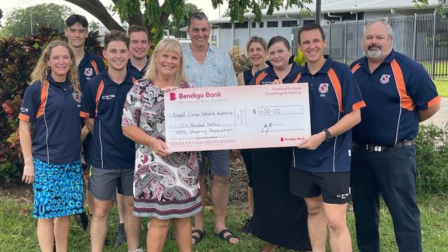 Sharyn Morcom, Sean Parnell and Umpire's Association president Mark Noonan present a cheque to the Breast Cancer Network Australia.