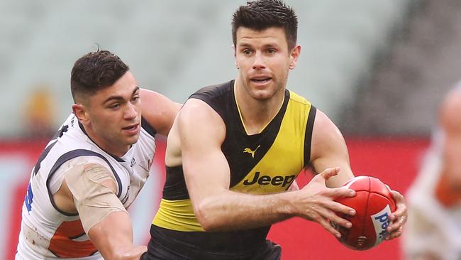 Trent Cotchin evades Tim Taranto at the MCG.