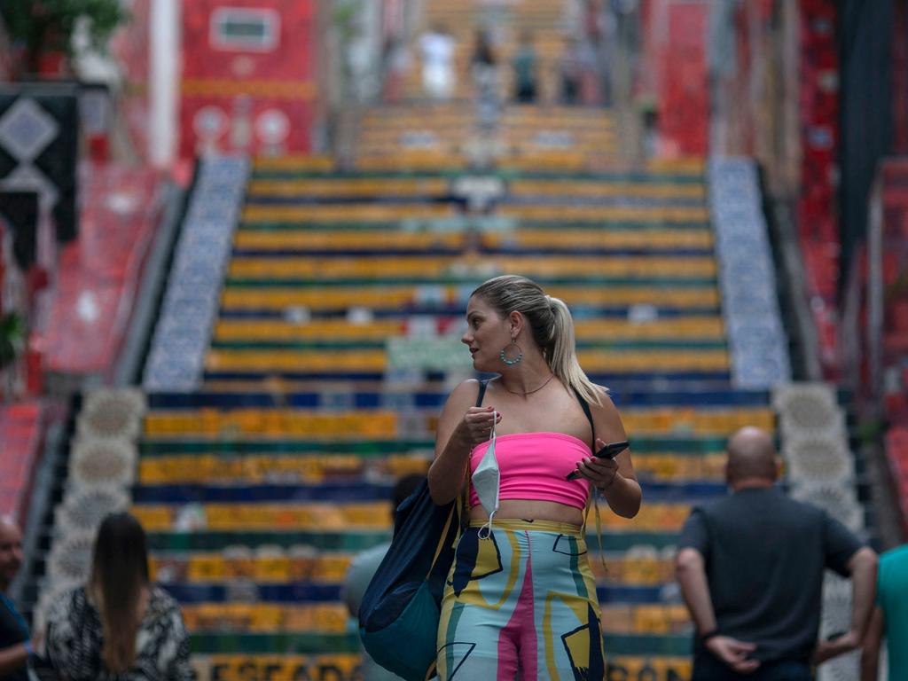 A tourist with her face mask in her hand, visits the Selaron staircase in Rio de Janeiro, Brazil, on April 29, 2021, as the country surpasses 400,000 deaths due to COVID-19. Picture: Mauro Pimentel/AFP