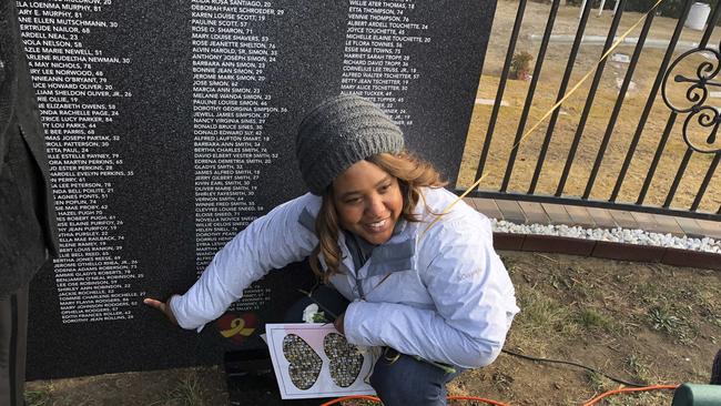 Erica Harden points out the names of six of her relatives who died in Jonestown. Picture: AP