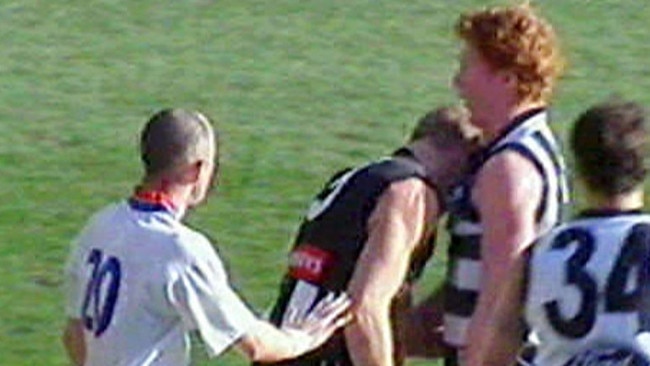 Buckley wipes his blood on Cameron Ling’s jumper with umpire Darren Morris watching.