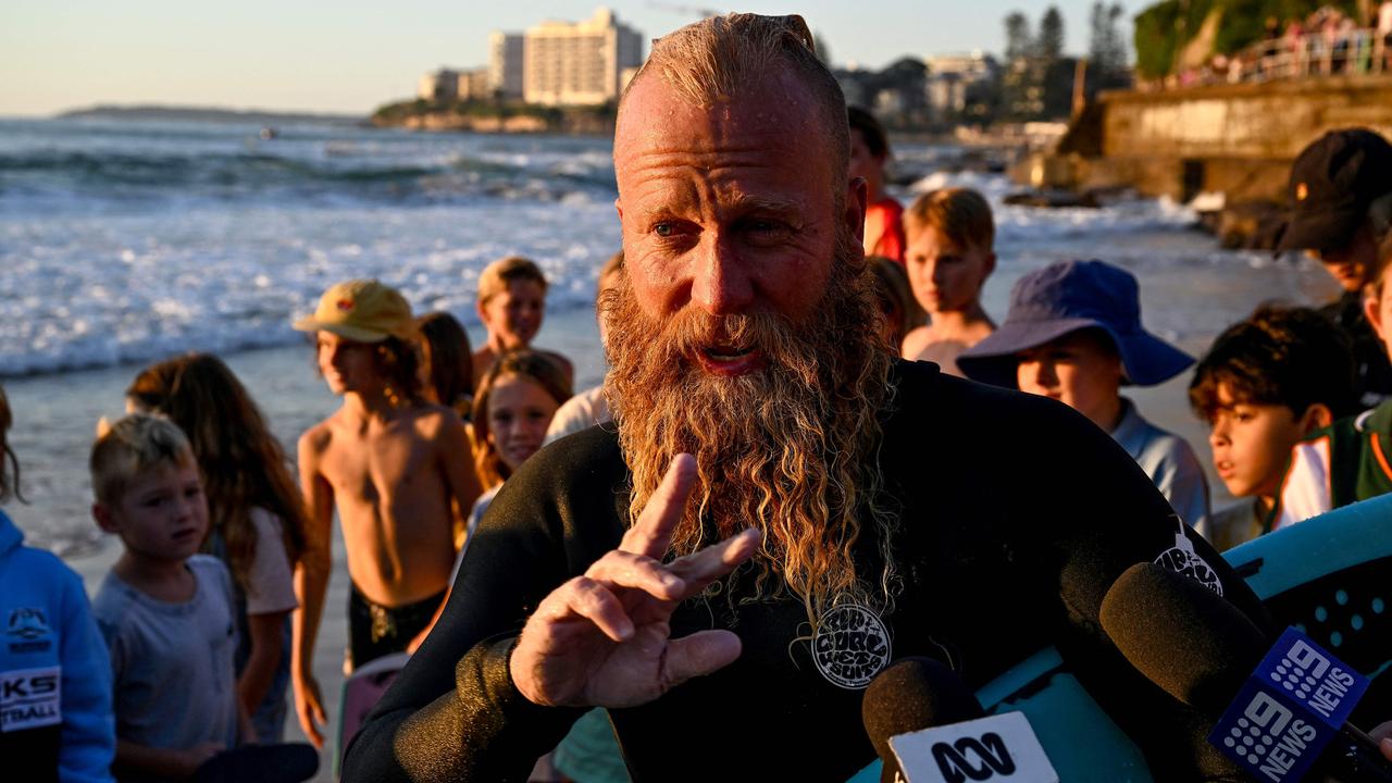 Australian former professional surfer Blake Johnston speaks to the media after breaking the record for the world's longest surf session on Cronulla Beach.. (Photo by Saeed KHAN / AFP)