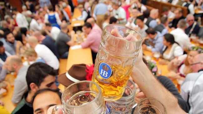 Revelers enjoy drinking beer inside the Hofbrau beer tent during the opening weekend of the 2019 Oktoberfest. (Photo by Johannes Simon/Getty Images)