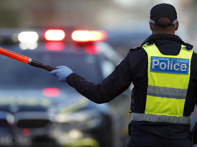 MELBOURNE, AUSTRALIA - JULY 02: Police check the identification of members of the public at a pop up road block in Broadmeadows to ensure they have legitimate reasons for leaving one on the hotspots, July 02, 2020 in Melbourne, Australia. Lockdowns across Melbourne have come into effect for residents of suburbs identified as COVID-19 hotspots following a spike in new coronavirus cases through community transmission. From midnight Wednesday 1 July, residents of 10 postcodes will only be able to leave home have for exercise or work, to buy essential items including food or to access childcare and healthcare. Businesses and facilities in these lockdown areas will also be restricted and cafes and restaurants can only open for take-away and delivery. The restrictions will remain in place until at least 29 July. (Photo by Darrian Traynor/Getty Images)