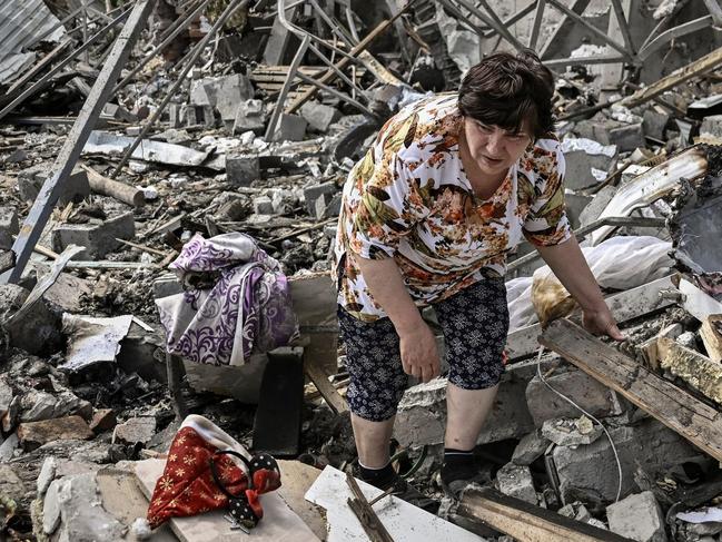 TOPSHOT - Residents look for belongings in the rubble of their home after a strike destoyed three houses in the city of Slovyansk in the eastern Ukrainian region of Donbas on June 1, 2022. (Photo by ARIS MESSINIS / AFP)