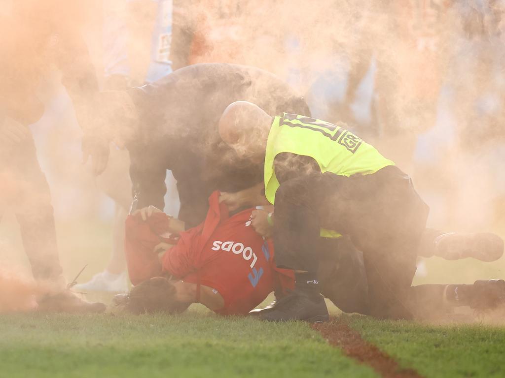 The pitch invade is tackled by security during the round five NRL match between the Cronulla Sharks and the Wests Tigers. Picture: Mark Kolbe/Getty Images