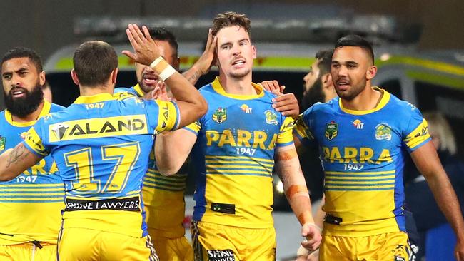 Clinton Gutherson of the Eels is congratulated by his teammates after scoring a try.