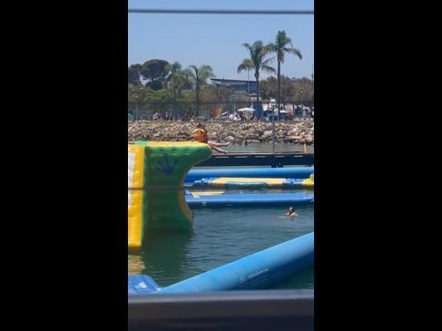 Woman falls off inflatable obstacle course