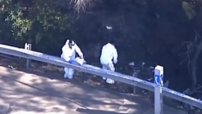 Police search the side of the road following the discovery of a woman’s body. Picture: 7 News