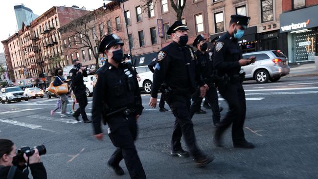 Police follow marchers after the verdict of the Derek Chauvin trial in Brooklyn on April 20, 2021 in New York City.