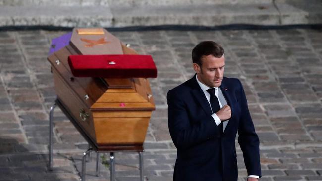 French President Emmanuel Macron pays his respects by the coffin of Samuel Paty's coffin inside Sorbonne University's courtyard in Paris.