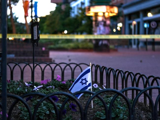 An Israeli flag stands in a bed of flowers as caution tape blocks off a deserted Pearl Street on the scene of an attack on protesters for Israeli hostages held in Gaza, in Boulder, Colorado. Picture: AFP