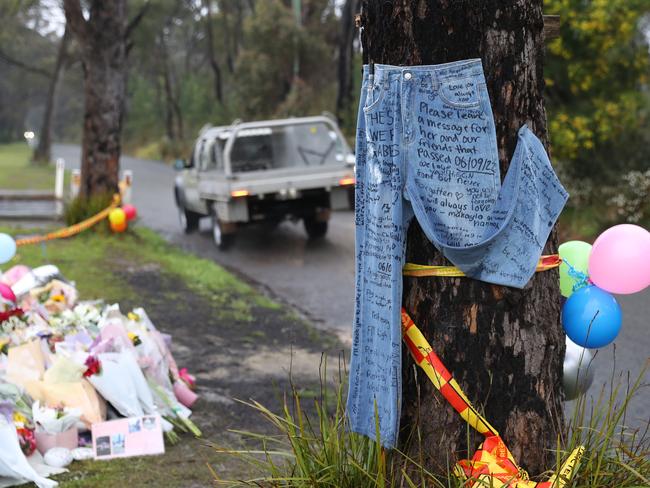 A pair of jeans left as a message board and a the growing flower memorial for the five teens killed in a crash on East Pde Buxton. Picture: John Grainger