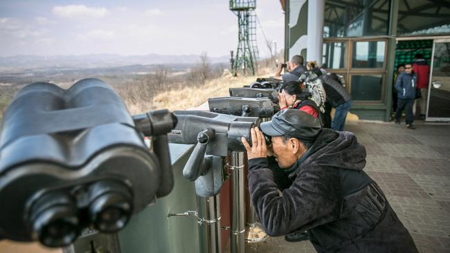 Tourists look towards the Kaesong Industrial Complex in North Korea as they visit Dora Observatory inside the fortified Demilitarised Zone (DMZ). Picture: Jean Chung/Getty