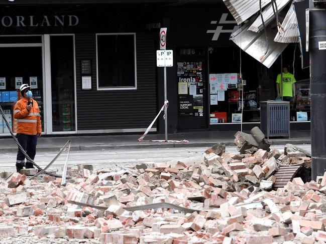 An emergency and rescue official examines the damage to a building in Melbourne’s Chapel Street after Wednesday’s earthquake. Picture: William West/AFP