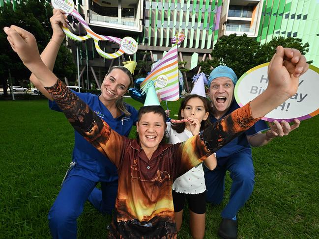 Celebrating 10 years of Queensland Children’s Hospital are (from left) nurse Maddie Randall, Joey Donald, 14, Julia Preston, 9, and chief of surgery Stuart Bade. Picture: Lyndon Mechielsen