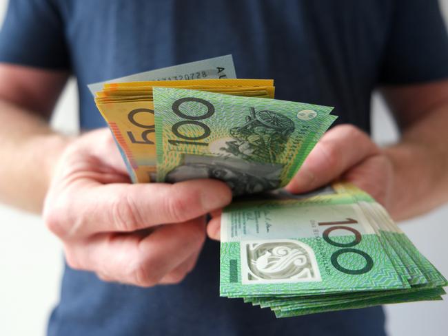 A man counting Australian dollar bills. A picture that describes buying, paying, handing out money, or showing money.