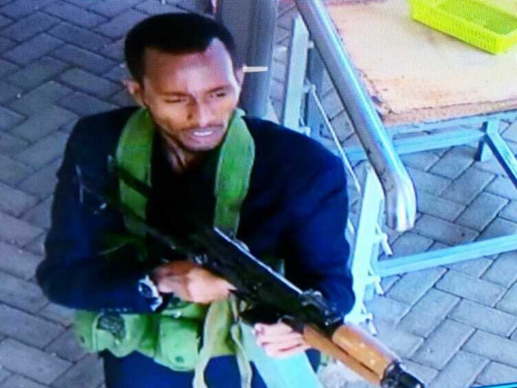 In this grab taken from security camera footage released to the local media, an armed attacker walks in the compound of a hotel, in Nairobi, Kenya, Tuesday, Jan. 15, 2019. Extremists launched an attack on a luxury hotel in Kenya's capital, sending people fleeing in panic as explosions and heavy gunfire reverberate through the neighborhood. A police officer says he saw bodies, "but there was no time to count the dead." Al-Shabab _ the Somalia-based extremist group _ is claiming responsibility. (Security Camera Footage via AP)