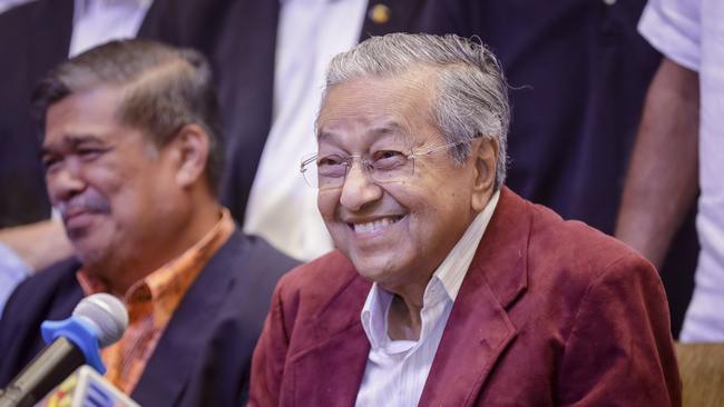 Mahathir Mohamad, center, celebrates at a hotel in Kuala Lumpur, Malaysia, Wednesday, May 9, 2018. Official results from Malaysia's national election show the opposition alliance led by the country's former authoritarian ruler Mahathir Mohamad has won a majority in parliament, ending the 60-year rule of the National Front. (AP Photo/Adrian Hoe)