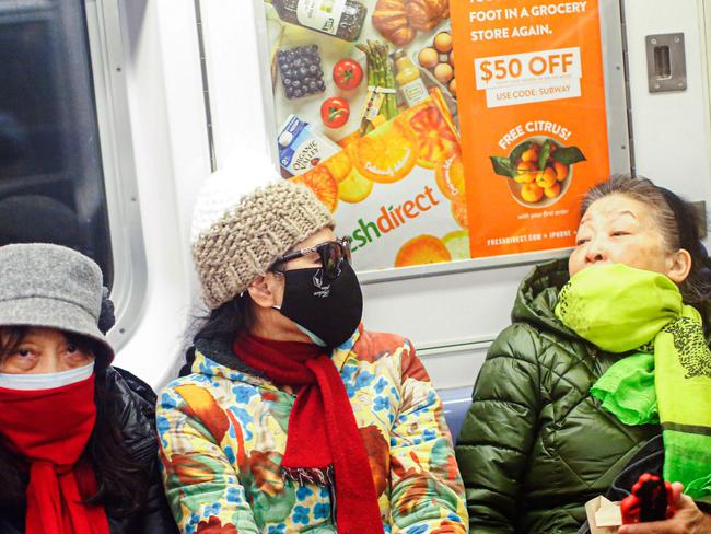 Women wear face masks as they ride the New York City subway. Picture: AFP