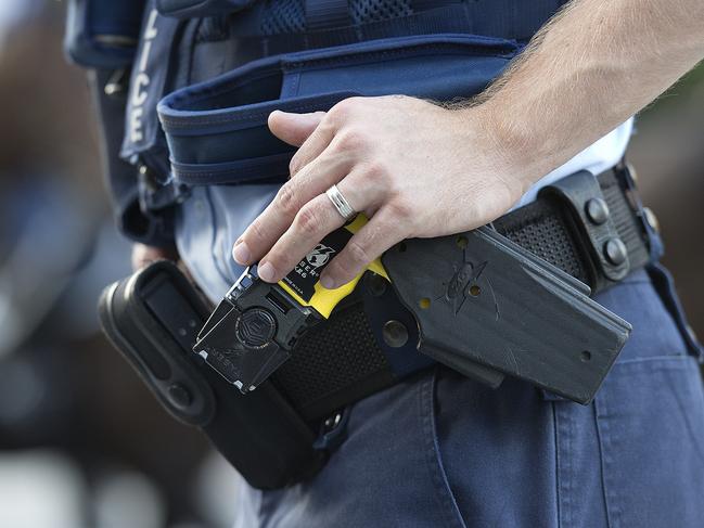 Stock photograph of a Queensland Police Officer with his hand on a Taser in the Brisbane CBD, Friday, Feb. 28, 2014. (AAP Image/Dave Hunt) NO ARCHIVING