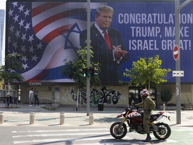 TEL AVIV, ISRAEL - NOVEMBER 7: People pass by a congratulatory billboard showing elected U.S. President Donald Trump on November 7, 2024 in Tel Aviv, Israel. In a post on X, Israeli Prime Minister Benjamin Netanyahu has congratulated Donald Trump on "history's greatest comeback," following Trump's victory in the US Presidential election. During his first term in office, Donald Trump implemented pro-Israel policies, including the controversial move of the US embassy from Tel Aviv to Jerusalem. (Photo by Amir Levy/Getty Images) *** BESTPIX ***