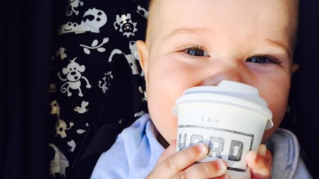 Henry holds a babycino coffee at the Yard Cafe, Mermaid Beach.