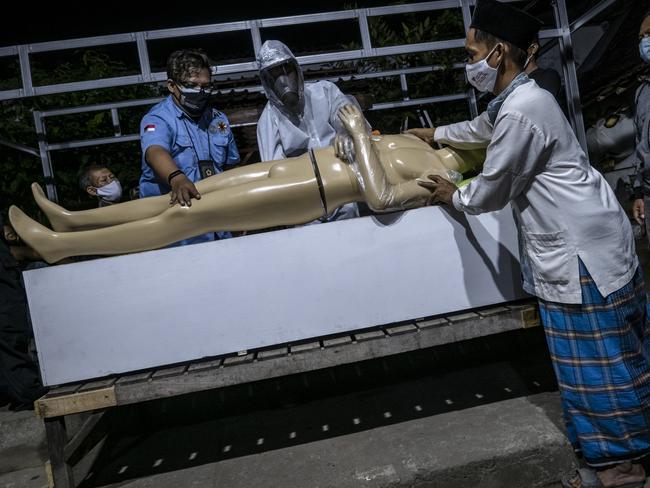 The burial team of the regional disaster management agency provide training for villagers on how to deal with a corpse who has died due to Covid-19 in Yogyakarta, Indonesia. Picture: Getty Images