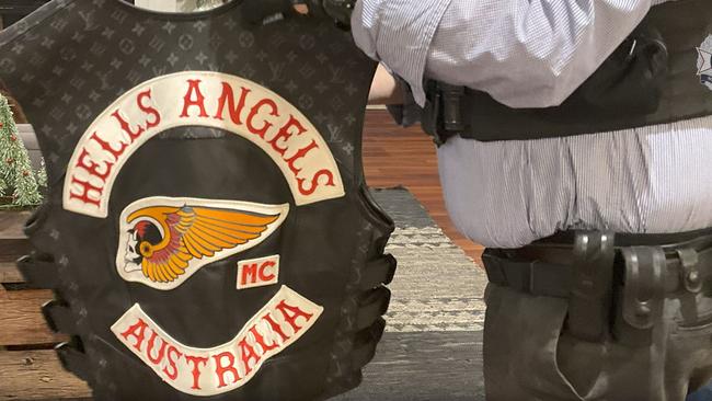 An alleged Hells Angel member has been charged with assault after an attack on a man at a public cafe