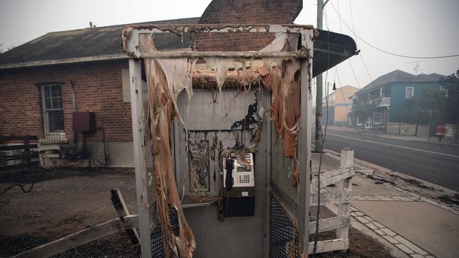 The phone box is melted, but somehow the handset survived. A phone box in the main Street of devastated Cobargo. Picture Gary Ramage