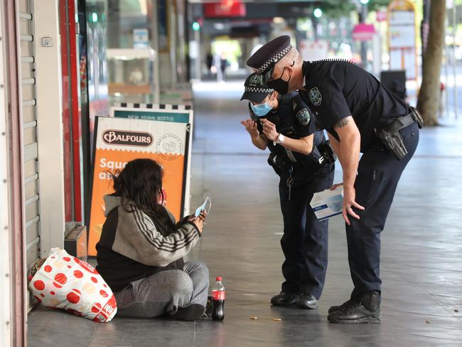 Police hand out masks to people in the city. Pic Tait Schmaal.