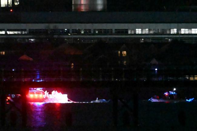 Two rescue boats pull debris from the water after a US passenger jet and a military helicopter crashed over the Potomac River near Reagan National Airport in Washington