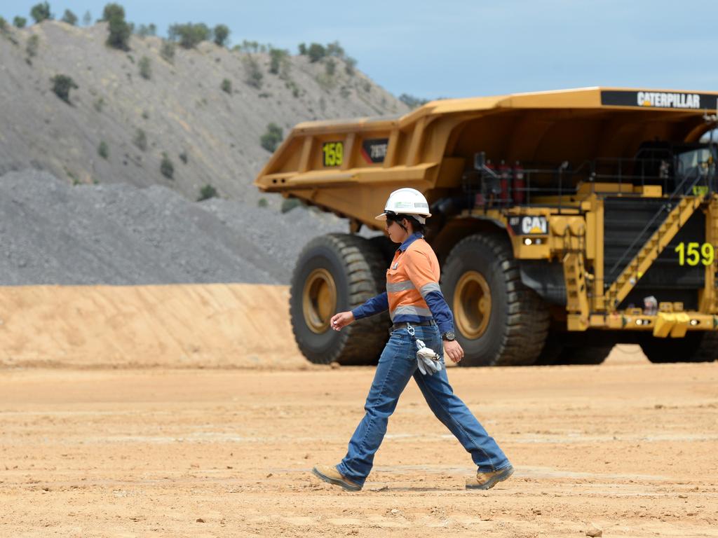 Shovel operator Sarah Engel walks past a dump truck at the Caval Ridge coal mine near Moranbah in Central Queensland.