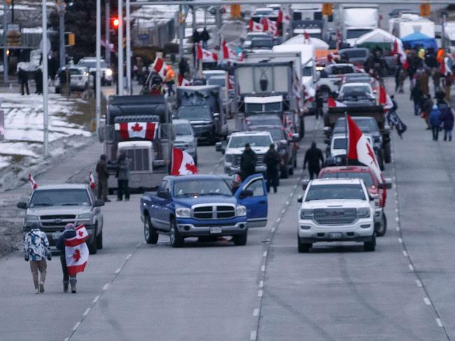 WINDSOR, ON - February 10: Protestors and supporters at a blockade at the foot of the Ambassador Bridge, sealing off the flow of commercial traffic over the bridge into Canada from Detroit, on February 10, 2022 in Windsor, Canada. As a convoy of truckers and supporters continues to occupy Ottawa's downtown, blockades and convoys have popped up around the country in support of the protest against Canada's COVID-19 vaccine mandate for cross-border truckers.   Cole Burston/Getty Images/AFP == FOR NEWSPAPERS, INTERNET, TELCOS & TELEVISION USE ONLY ==